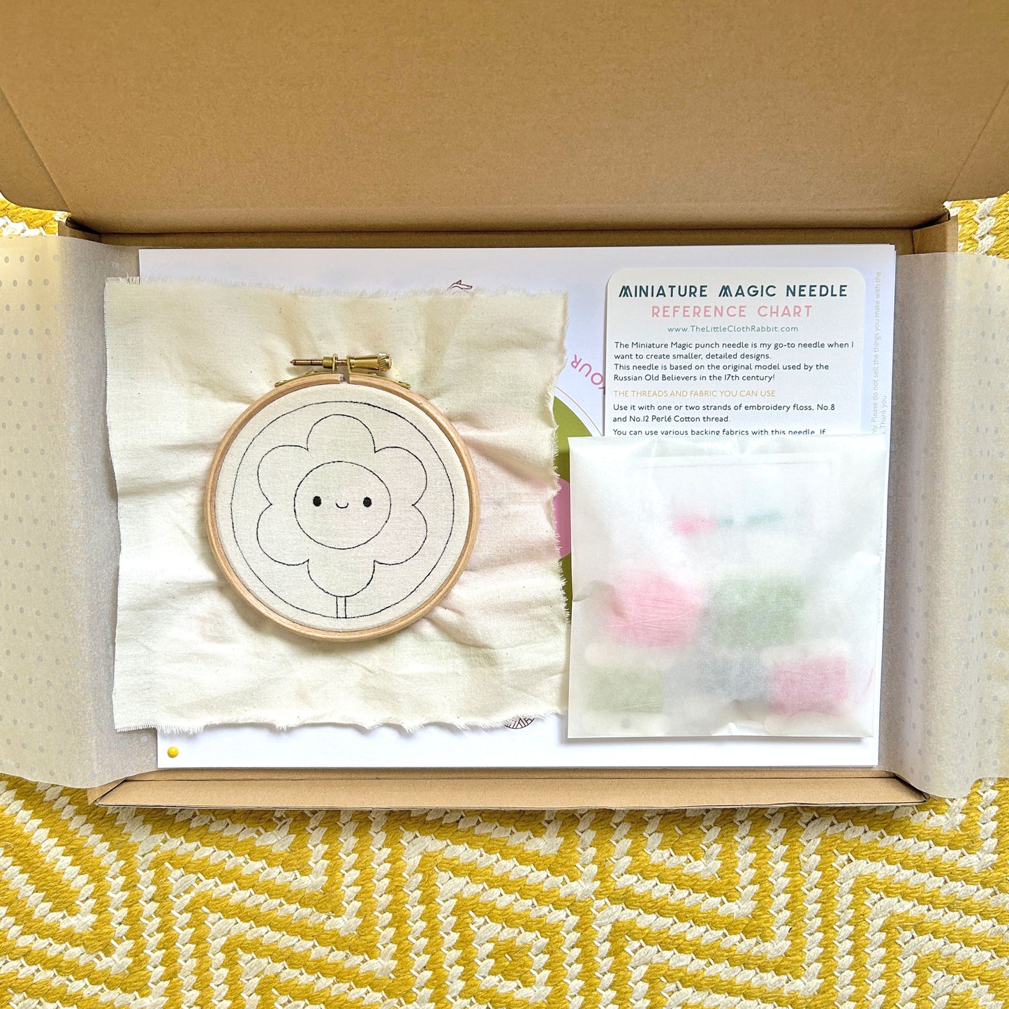 Miniature Punch Needle Flower Kit partially wrapped revealing kit contents inside box