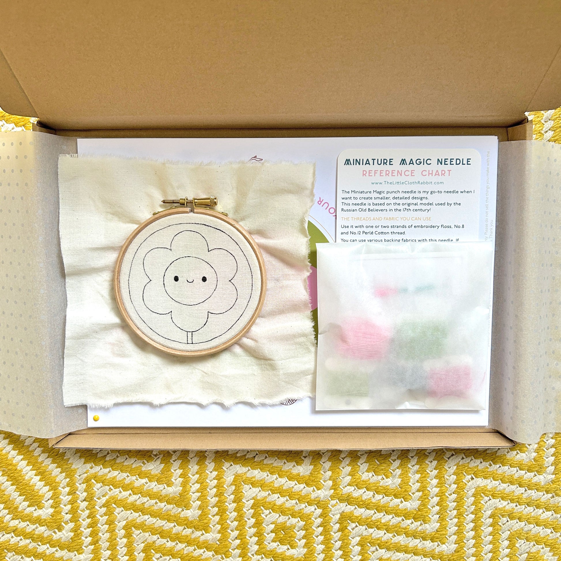 Miniature Punch Needle Flower Kit partially wrapped revealing kit contents inside box